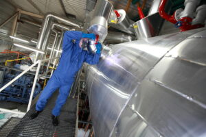 Technician using PPE while working with ammonia tank