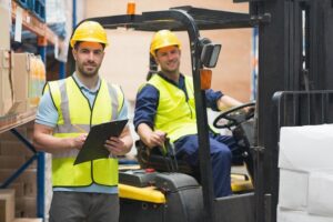 Two Men Smiling Sitting on a Forklift for Forklift Operator Certification Online